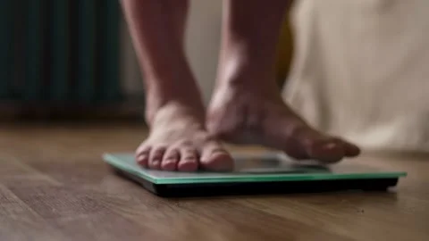 Close Up of Bare Feet Standing on Digital Weight Scale Vídeos de archivo 340219795