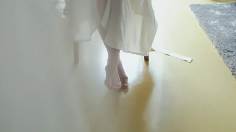 Close-up of bare feet on a white light floor. Bride in a gown waiting for her Stock Footage 308788865