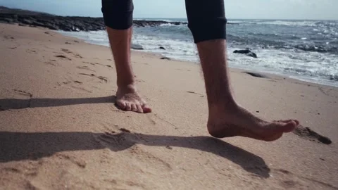Close-up of bare guy feet walking along the sandy coast on a warm day. Legs.. Stock Footage 240404073