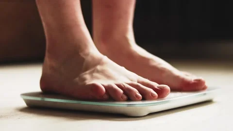 Close-up of bare man's feet on a digital bathroom smart scale. 库存影片 325036228