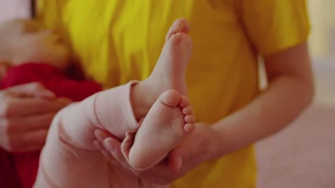 Close-up of barefoot tiny infant baby feet in mothers hand Stock Footage 240699047