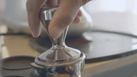 Close-up barista presses the roasted coffee powder into a block for the machine. Stock Footage 148657804