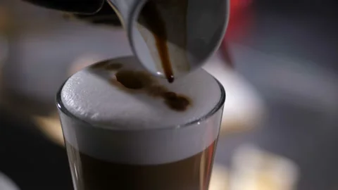 Close up barista's hand making pattern on cap foam Stock Footage 124888946