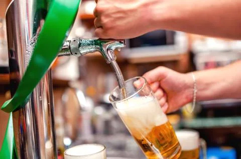 Close-up of barman brewing a draft beer at pub Stock Photos