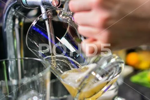 Close-up of barman hand at beer tap pouring a draught lager beer Stock Photos