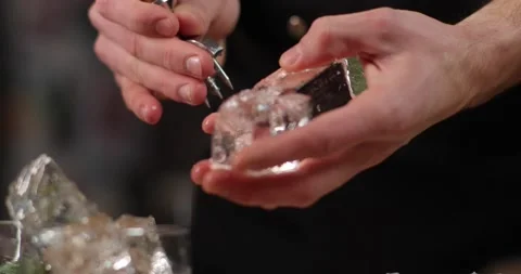 Close-up barman hands prick ice for cocktails. Stock Footage 162371070