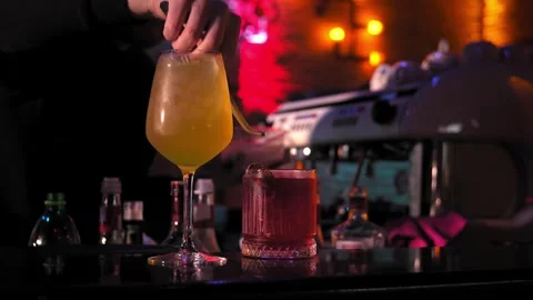 Close-up of bartender adding pieces of fruit finished cocktails on bar counter Stock Footage 269560442