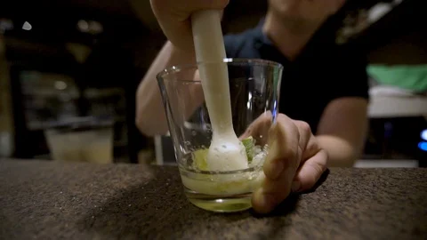 Close up bartender crushing lime in cocktail Video stock 104017984