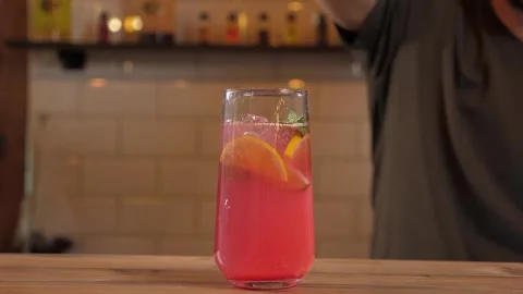 Close-up of a bartender in gloves putting ice cubes in a glass with berry juice. 스톡 동영상 346441936
