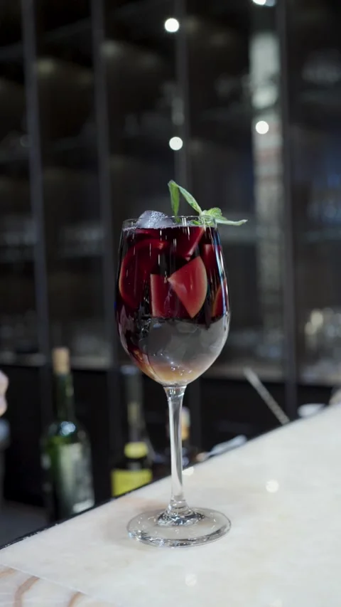 Close-up of a bartender hand adding a sprig of fresh mint to a glass of red.. Stock Footage 333915149