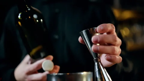 Close-up of a bartender measuring red wine into a stainless steel jigger and Stock Footage 318649549