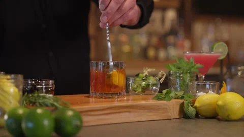 Close Up of Bartender Mixing a smokey whiskey bourbon cocktail mixology drink Видео 246702796