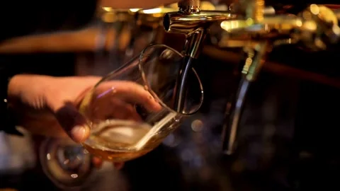Close up of bartender pouring beer. After closing the tap for pouring beer, t Stock Footage 265766201