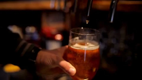 Close up of bartender pouring beer. After closing the tap for pouring beer, t Stock Footage 265766544