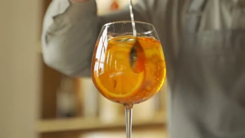 Close-up bartender prepares a cocktail hand stirring a orange summer cocktail Stock Footage 153455783
