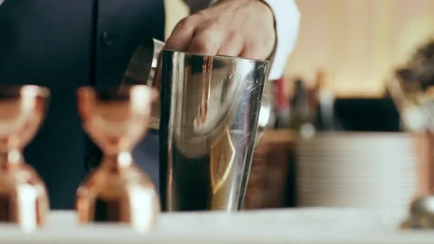 Close up of bartender putting ice with tongs into shaker in a beautiful modern t Stock Footage 199463182