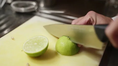 A close-up bartender slices ripe lime on a white kitchen board in the mojito Stock Footage 201876960