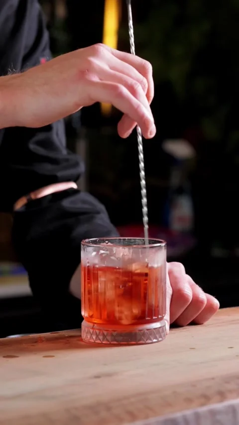 Close-up of Bartender Stirring Drink with Ice, Vertical Slow-Motion Video Stock Footage 288577520