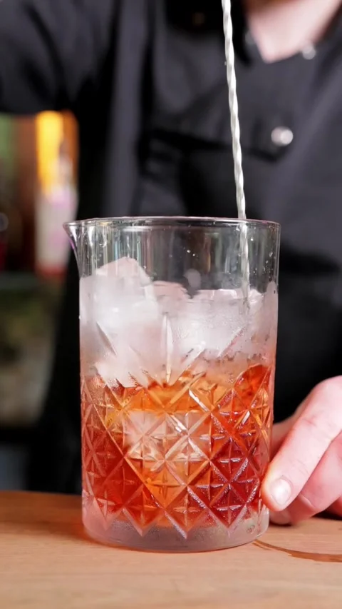 Close-up of Bartender Stirring Drink with Ice, Vertical Slow-Motion Video Stock Footage 288577593