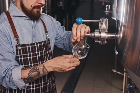Close up of bartender at work pouring beer. Stock Photos