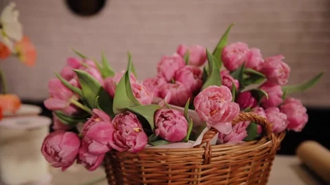 Close-up of basket full of spring pink flowers. Basket full of tulips on table Stock Footage 281248339