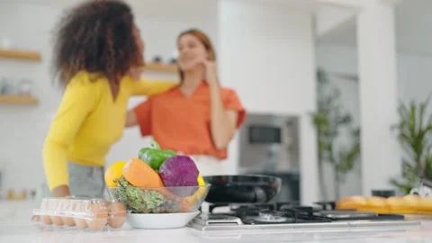 Close up basket of vegetables and eggs on table and background is lesbian couple Stock Footage 246533963