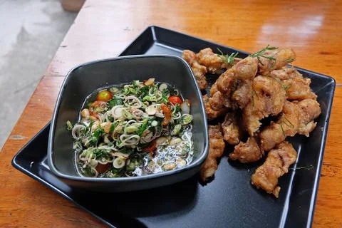 Close up battered and deep fried fish with herbal sauce Stock Photos