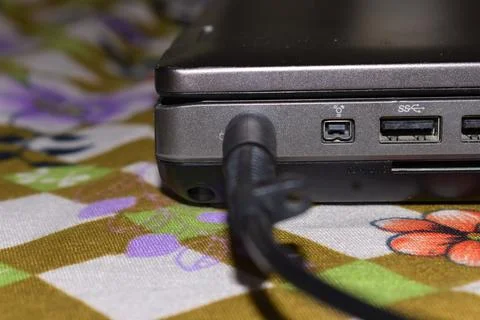 Close up of battery charge on laptop computer with power plug on bed Stock Photos