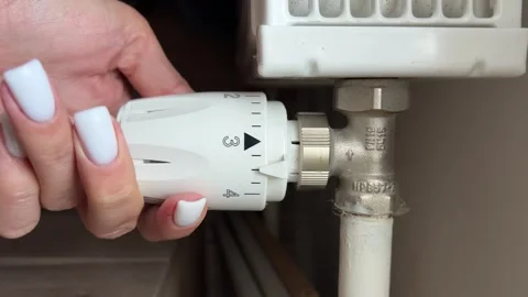 Close-up of a battery with a regulating knob, hand increasing the temperature of Stock Footage 318444092