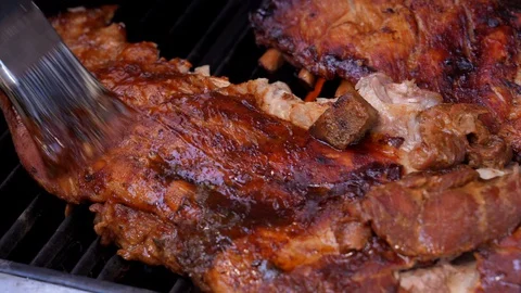 Close up bbq brush slathers bbq sauce on ribs grill Stock Footage 129902808