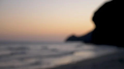 Close up of beach at sunset. The waves break on the black sand. 4K Stock Footage 125492006