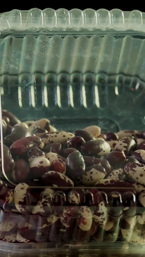 Close-up, beans into plastic packaging, box, rotates on black background. Stock Footage 319656551