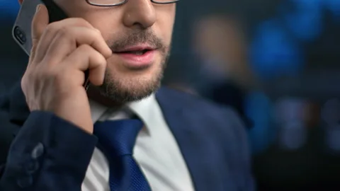 Close up bearded male mouth talking smartphone discussing job at hi tech office Stock Footage