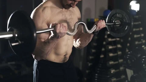 Close up of a bearded man doing the last set of a barbell exercise Stock Footage 74276980