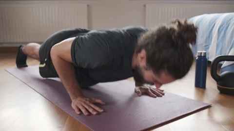 Close-up of a bearded man doing push ups at home during his daily exercise. Stock Footage 158487898