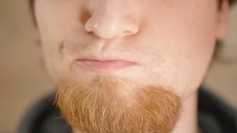 Close-Up of a Bearded Man Drinking Green Liquid from a Small Transparent Cup for Stock Footage 306438349