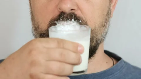 Close-up, bearded man drinking kefir from a glass glass. Stock Footage 143396489