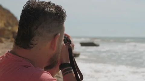 Close-up. A bearded man holds a camera in his hands and takes pictures Stock Footage 132908088