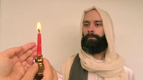Close-up bearded man in image of Savior holding burning candle, Jesus Chris.. Stock Footage 234828747