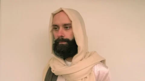 Close-up bearded man in image of Savior holding burning candle, Jesus Chris.. Stock Footage 236375608