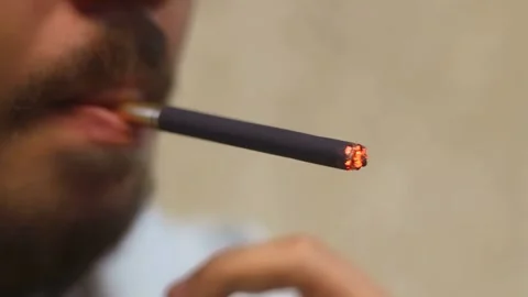 Close-up of a bearded man lighting a black cigarette Stock Footage 316268556