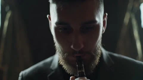Close-up of a bearded man in suit smoking electronic cigarette Stock Footage 56899088