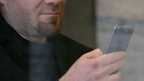 Close up on bearded man typing on smartphone behind a glass window Stock-Footage 74704530