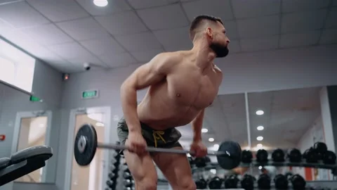 Close-up of the bearded, muscular man doing deadlifts with the bar in the gym Video stock 156471208