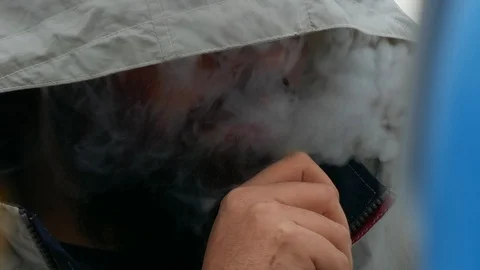 Close up of a bearded young man smoking with a hat covering his face Stock Footage 97035726