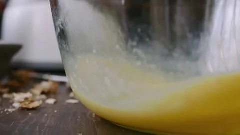 Close up of beating eggs in a glass mixing bowl	 Stock Footage 75759548