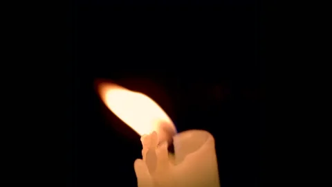 Close up of a beautiful burning candle isolated on black background Stock Footage 164066898