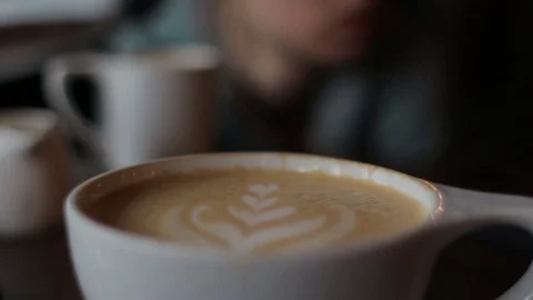 Close up of beautiful coffee standing at table in cafe. Woman drinking coffee Stock-Footage 75251738