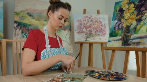 Close up of beautiful creative painter painting on a list of paper in her art Stock Footage 74198250