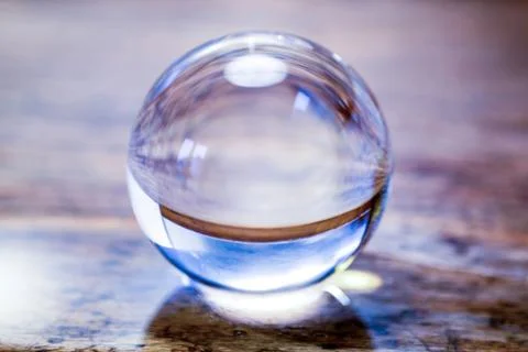 Close-up of beautiful glass sphere on rustic wooden table Stock Photos